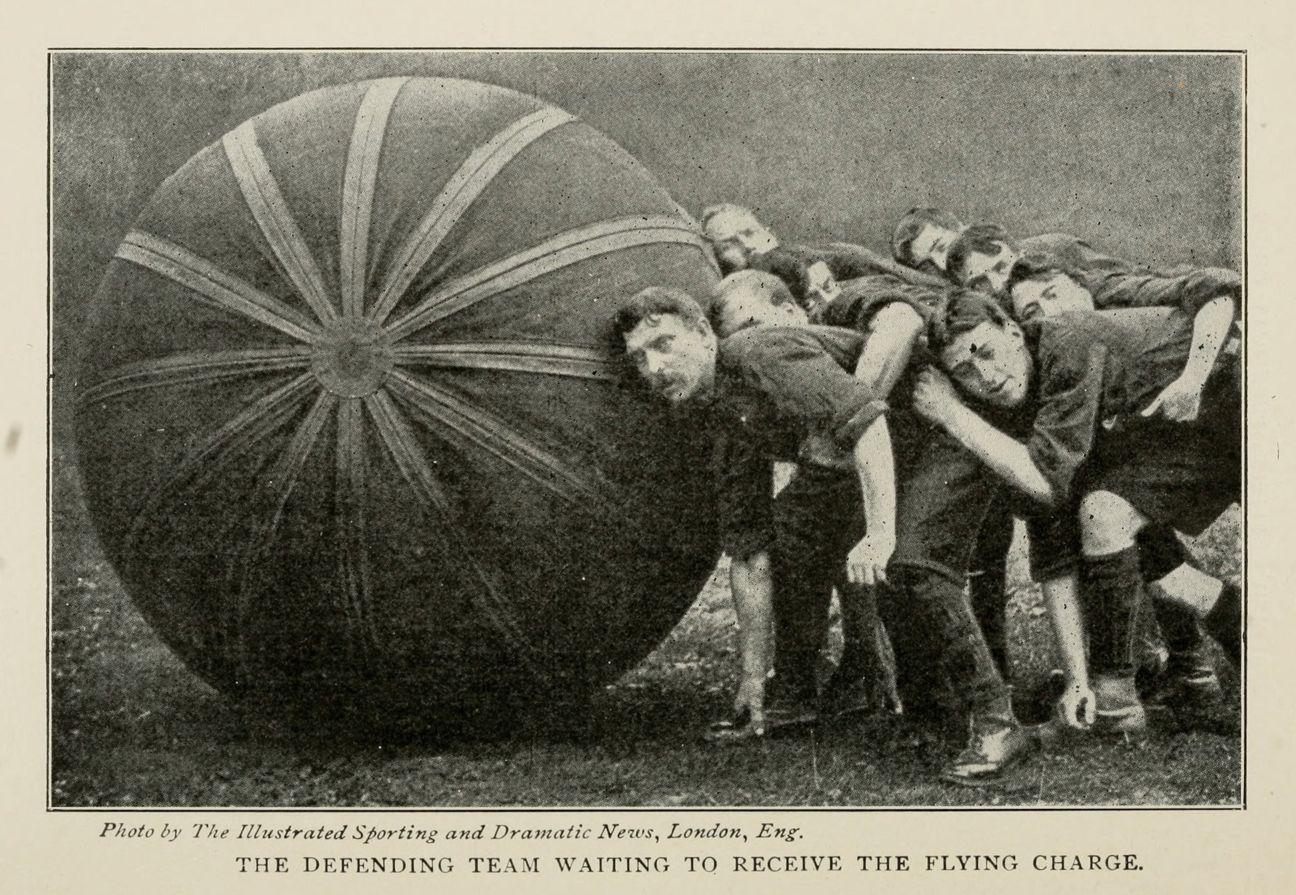 The Defending Team Waiting to Receive the Flying Charge — players braced behind a large striped pushball